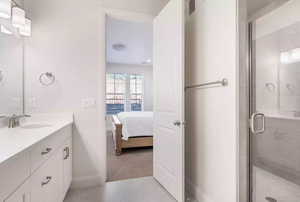 Bathroom featuring walk in shower, tile flooring, and vanity