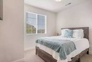 Bedroom featuring light colored carpet