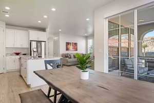 Dining space with sink, a wealth of natural light, and light wood-type flooring