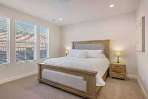 Carpeted bedroom featuring multiple windows