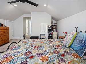 Carpeted bedroom with lofted ceiling, ceiling fan, and a textured ceiling