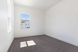 Spare room featuring dark colored carpet