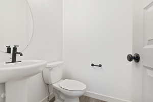 Bathroom with hardwood / wood-style flooring and toilet