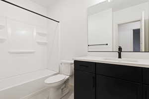 Full bathroom with bathtub / shower combination, tile flooring, toilet, and vanity