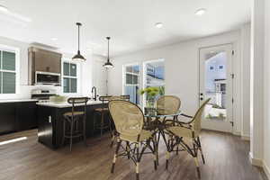 Dining space featuring dark hardwood / wood-style floors, sink, and a healthy amount of sunlight