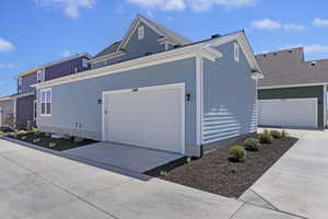 View of property exterior with a garage and central AC