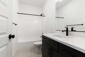 Full bathroom with shower / tub combination, vanity, toilet, and tile flooring