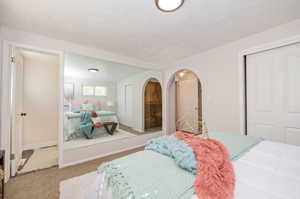 Carpeted bedroom with a textured ceiling