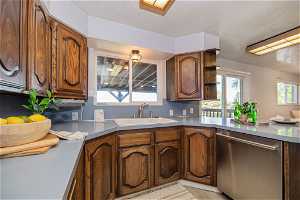 Kitchen with light hardwood / wood-style flooring, dishwasher, and sink