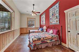 Tiled bedroom featuring ceiling fan
