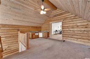 Bonus room featuring log walls, ceiling fan, light carpet, wood ceiling, and lofted ceiling