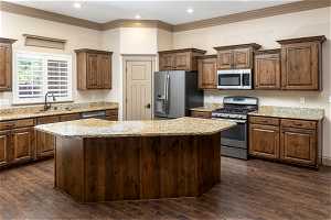 Kitchen featuring appliances with stainless steel finishes, a kitchen island, and dark hardwood / wood-style floors