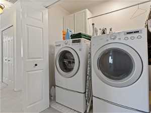 Washroom featuring light colored carpet and washer and clothes dryer