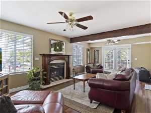Living room featuring dark hardwood / wood-style flooring, plenty of natural light, ceiling fan, and a tiled fireplace