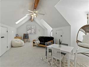 Carpeted bedroom featuring vaulted ceiling with skylight and ceiling fan