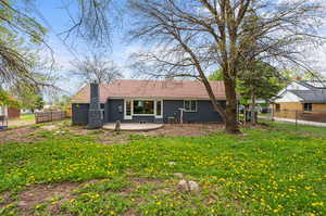 Rear view of house featuring a patio area and a lawn