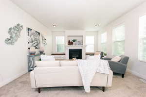 Living room featuring a tiled gas fireplace and light carpet