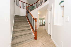 Entry way with vaulted ceiling and staircase.