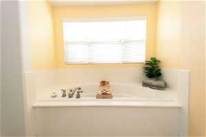 Master Bathroom with a healthy amount of sunlight and a garden tub