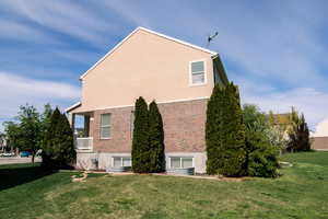 View of side of home with a yard