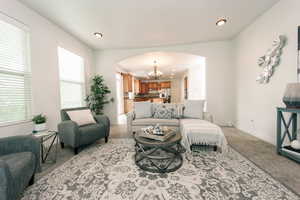 Carpeted living room featuring a chandelier