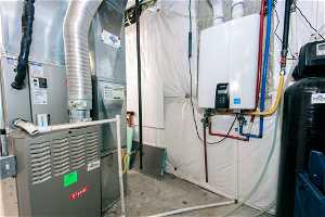 Utility room featuring tankless water heater and heating utilities