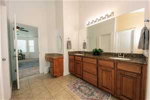 Master Bathroom with tile flooring, ceiling fan, vanity with extensive cabinet space, and double sink