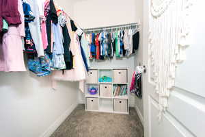 View of carpeted bedroom #2 featuring a walk-in closet and large windows.