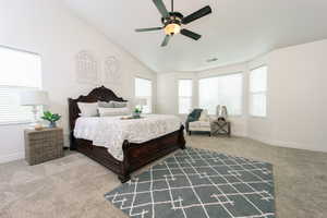 Carpeted bedroom featuring lofted ceiling and ceiling fan