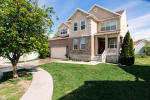 View of front of home with a garage and a front lawn