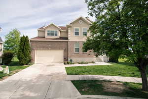 View of front facade featuring a garage and a front lawn