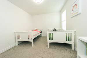 View of carpeted bedroom #2 featuring walk-in closet and large windows