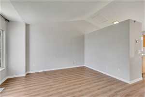 Empty room featuring light hardwood / wood-style floors and lofted ceiling