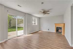 Unfurnished living room with light hardwood / wood-style flooring, ceiling fan, and a premium fireplace
