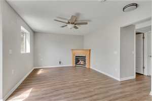 Unfurnished living room with light hardwood / wood-style floors and ceiling fan