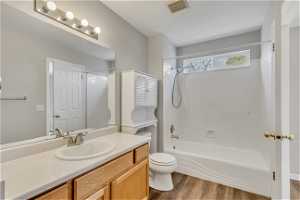 Full bathroom with shower / bathing tub combination, vanity, toilet, and hardwood / wood-style flooring