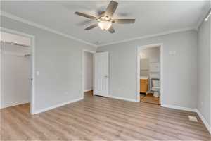 Unfurnished bedroom featuring a closet, light hardwood / wood-style flooring, ceiling fan, and ensuite bathroom