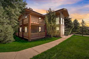 View of front of property featuring a yard and a wooden deck