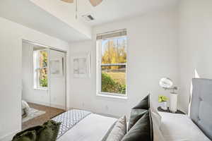 Carpeted bedroom featuring ceiling fan and a closet