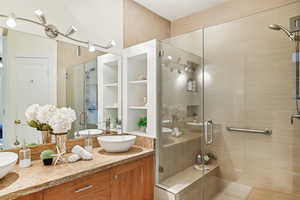 Bathroom with a shower with shower door and vanity