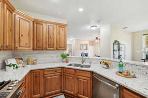 Kitchen with light stone countertops, stainless steel appliances, and sink