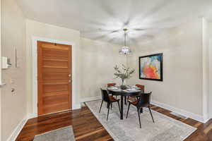 Dining room featuring dark wood-type flooring and a notable chandelier