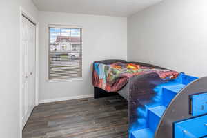 Bedroom with a closet and dark wood-type flooring