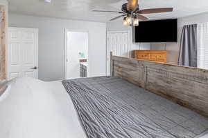 Primary bedroom featuring a closet, ceiling fan, and ensuite bath