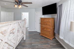 Primary bedroom featuring connected bathroom, ceiling fan, and dark hardwood / wood-style floors