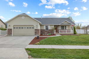 Ranch-style home featuring a front lawn, a garage, and a porch