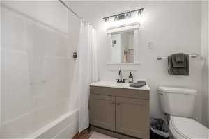 Full bathroom with vanity, tile floors, toilet, and shower / bath combo with shower curtain