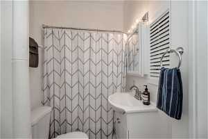 Bathroom with vanity, toilet, and tile walls