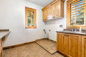 Laundry room with light tile flooring, hookup for an electric dryer, sink, cabinets, and washer hookup