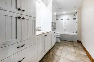 Full bathroom featuring tile floors, toilet, vanity, and tiled shower / bath